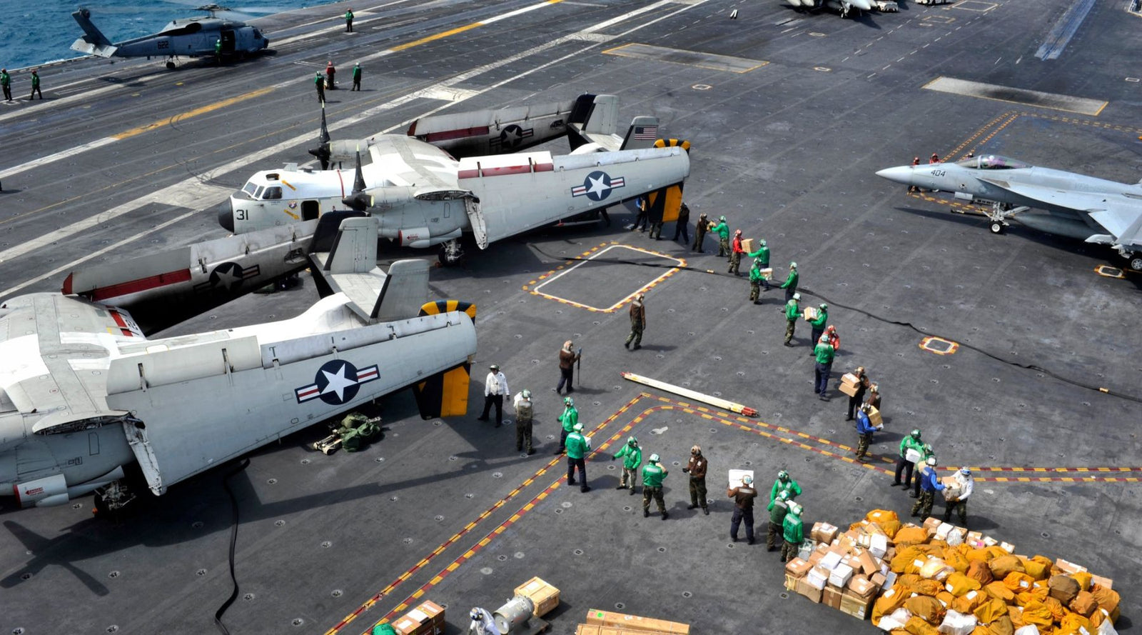 US Navy working party from vertical replenishment at sea with mail call on flight deck with personnel moving mail and other stores