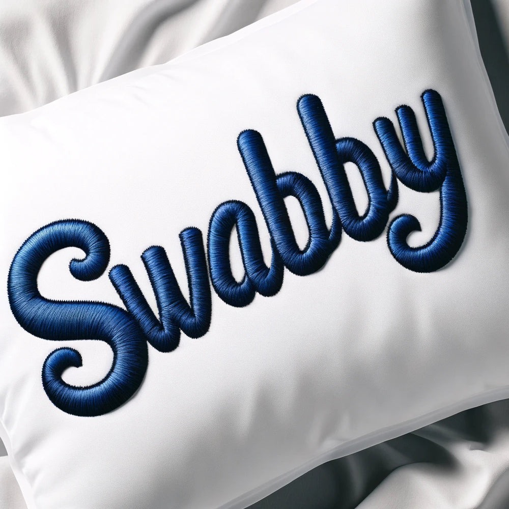 Custom embroidery name "Swabby" on a white pillowcase in navy blue text